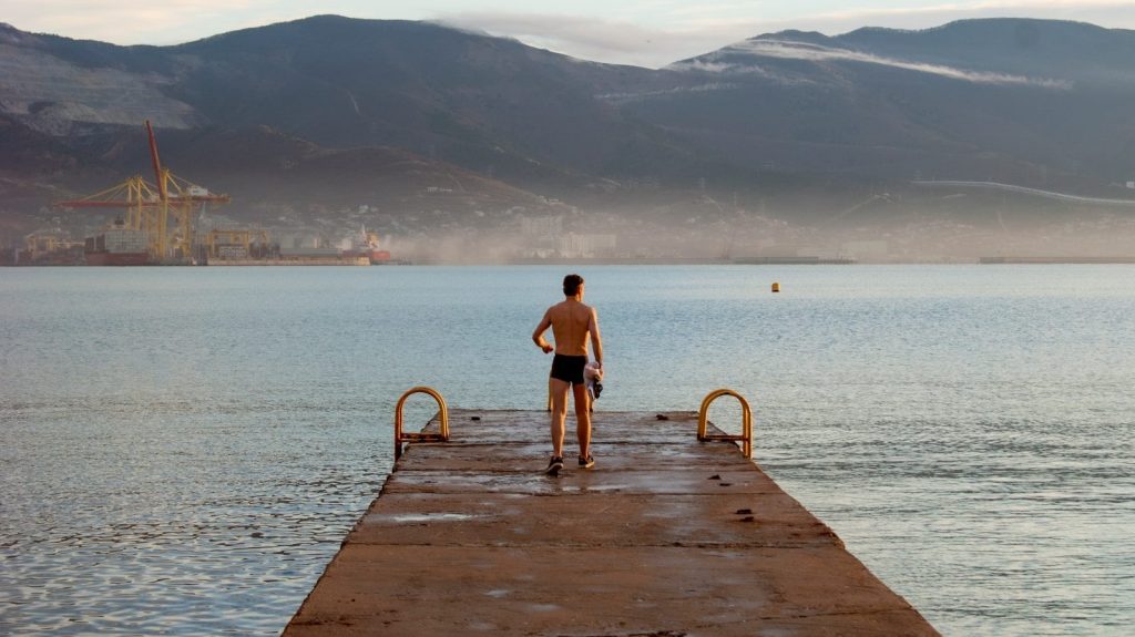 a man standing on a dock looking out at the water